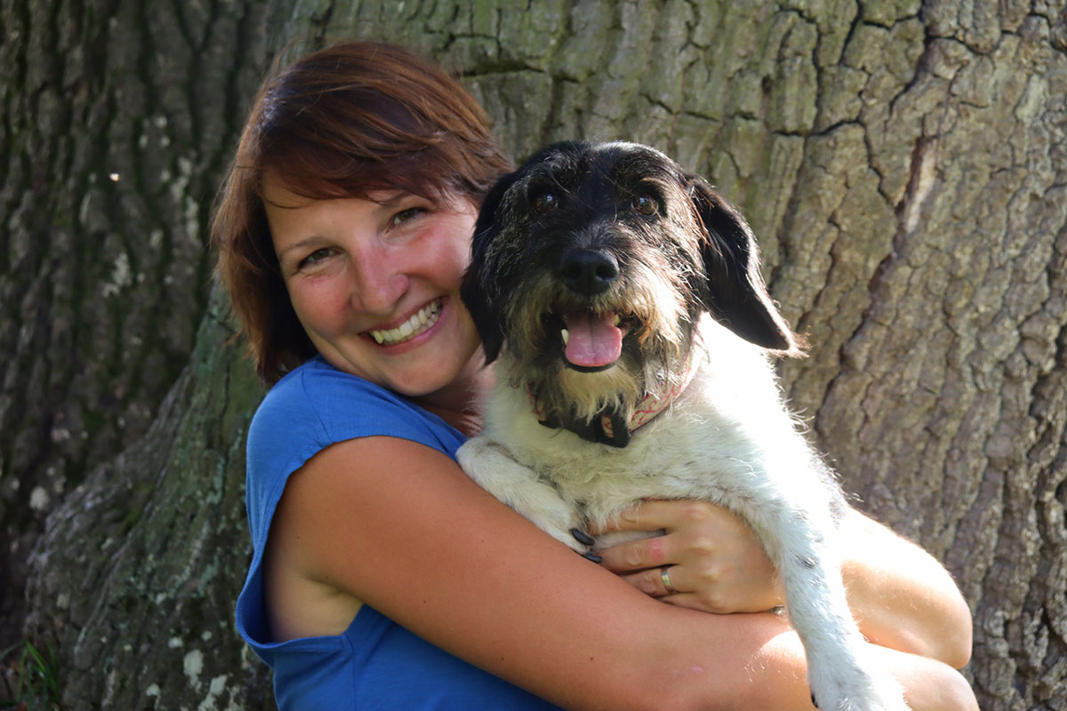 Majitelka salonu Eliška Sobotková usmívající se na kameru se svým psem v náručí
